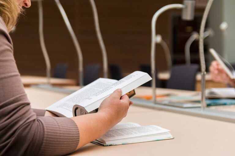 Student se učí na zkoušku na vysoké škole z učebnice